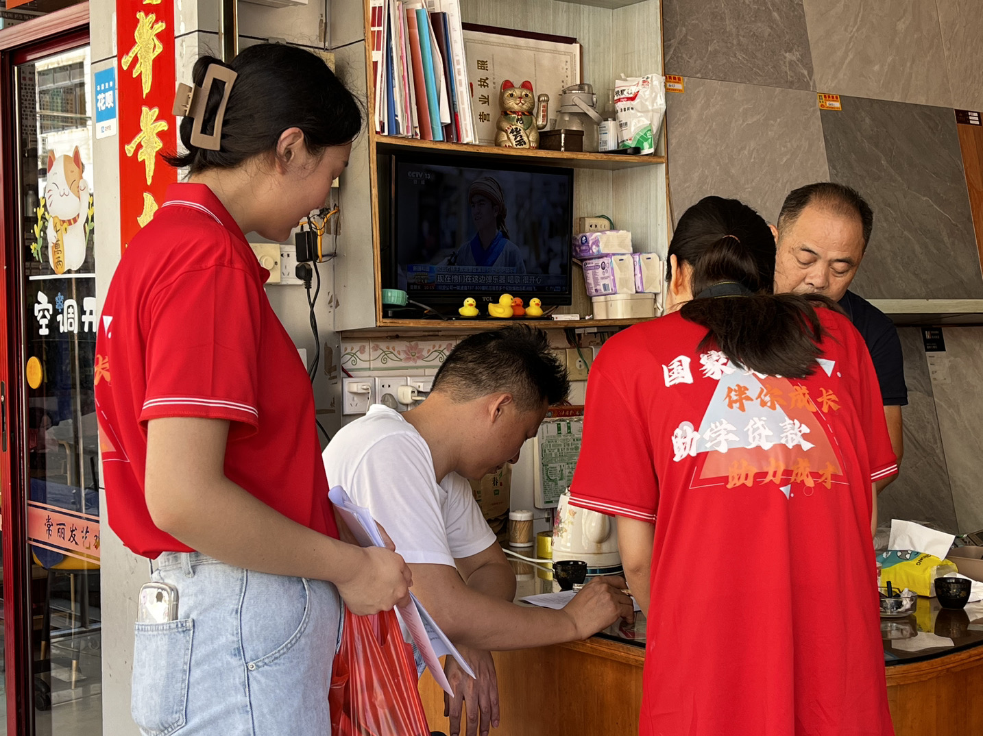 图为融媒体资助宣传实践队队员走访宣传资助政策现场。(林琳 供图)